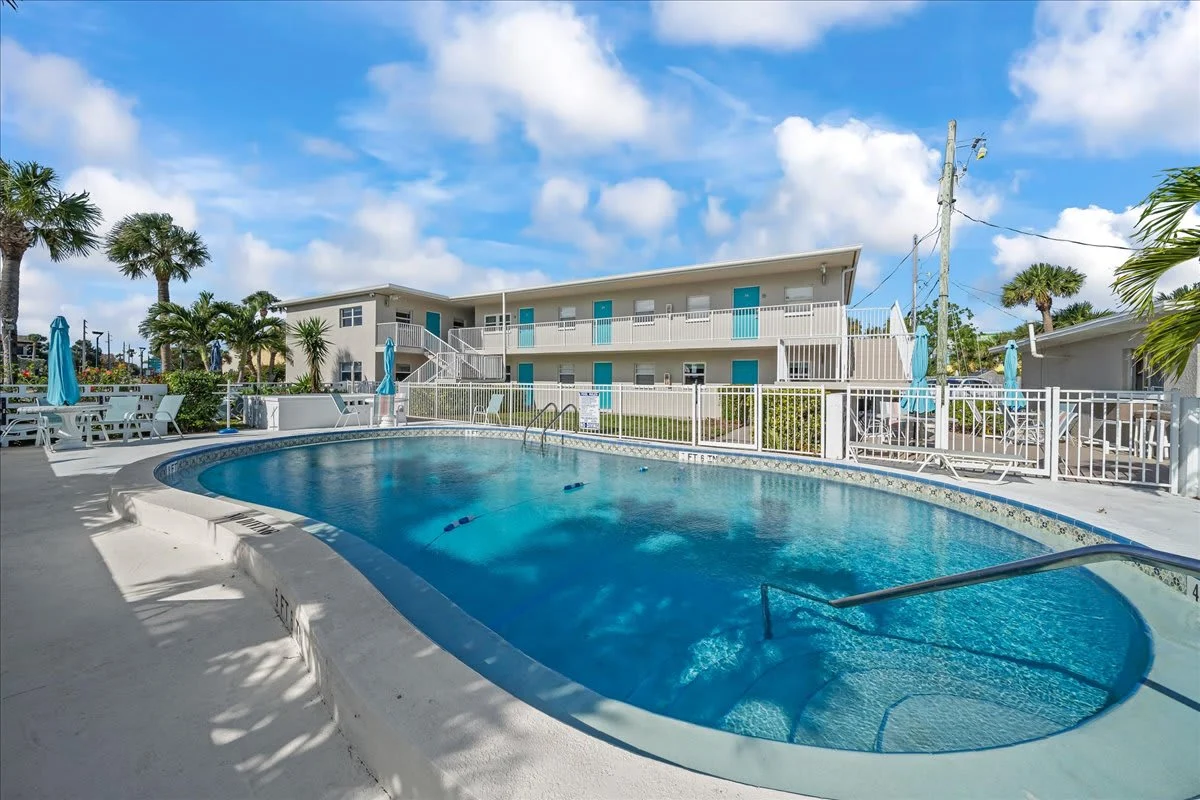 Living area of the Cozy Beachside Condo one-bedroom rental in Cape Canaveral, Florida, with sofa, TV and dining table