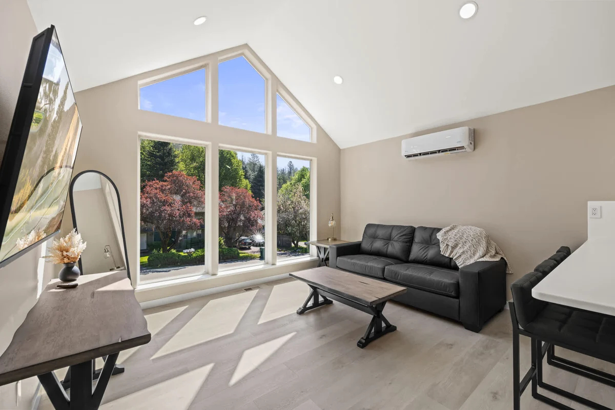 Bright living area with vaulted ceilings and oversized windows at Canfield Casita, a one-bedroom Coeur d'Alene vacation rental