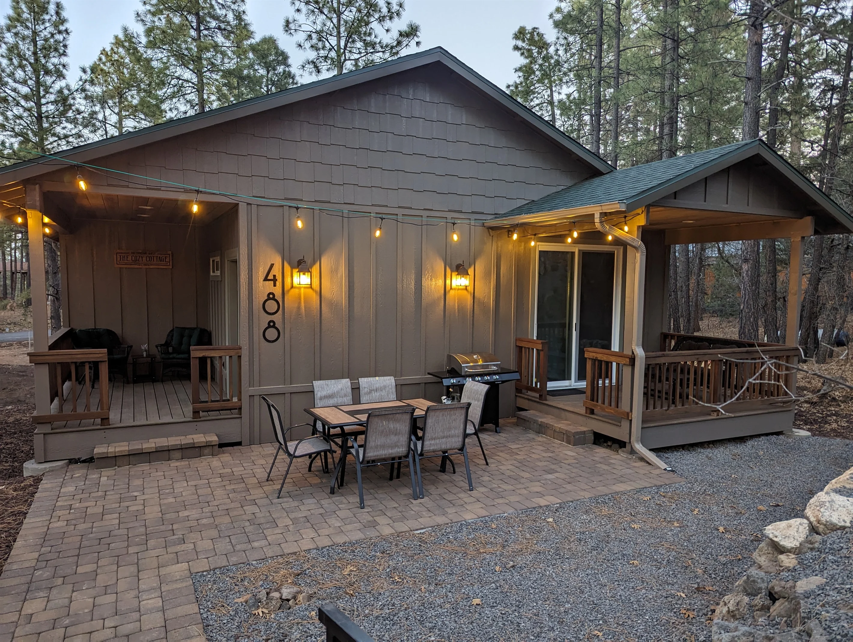 Cozy Cottage Lakeside exterior at dusk with string lights