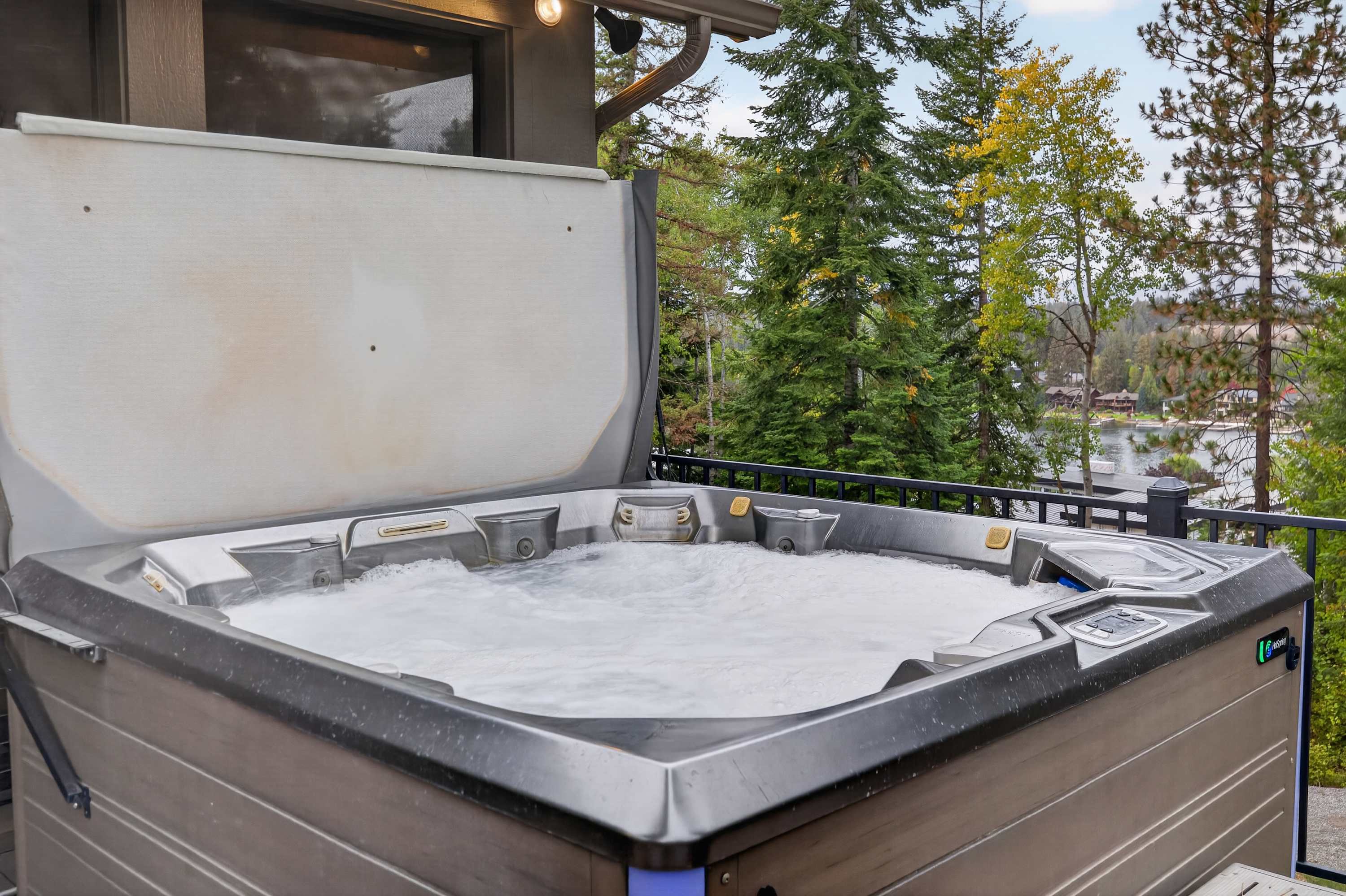 Eagles Nest private hot tub bubbling on the deck with river views and pine trees beyond