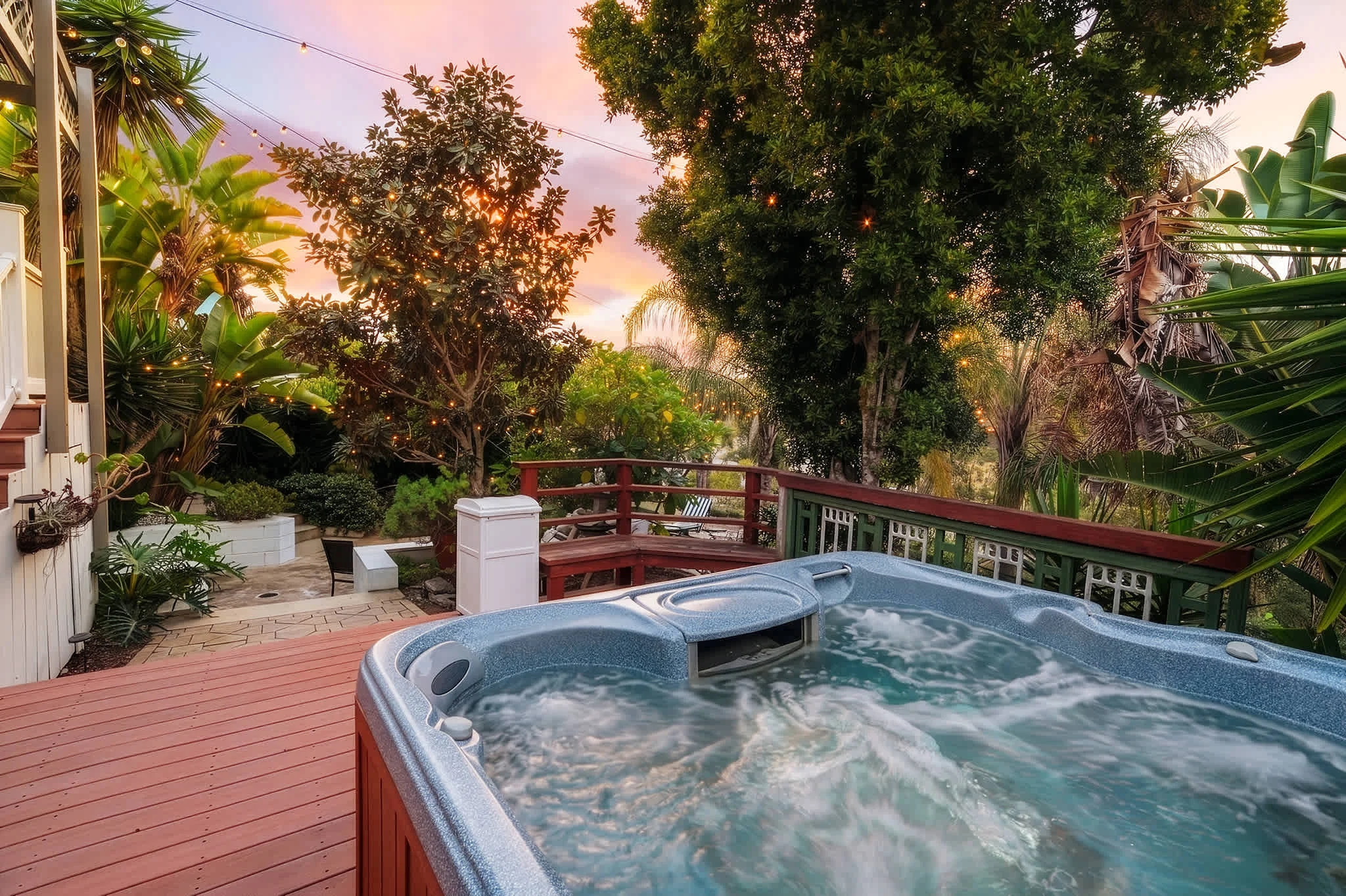 Backyard at Golden Hour Overlook in San Diego at sunset, with hot tub, fire pit lounge seating and outdoor dining under heaters
