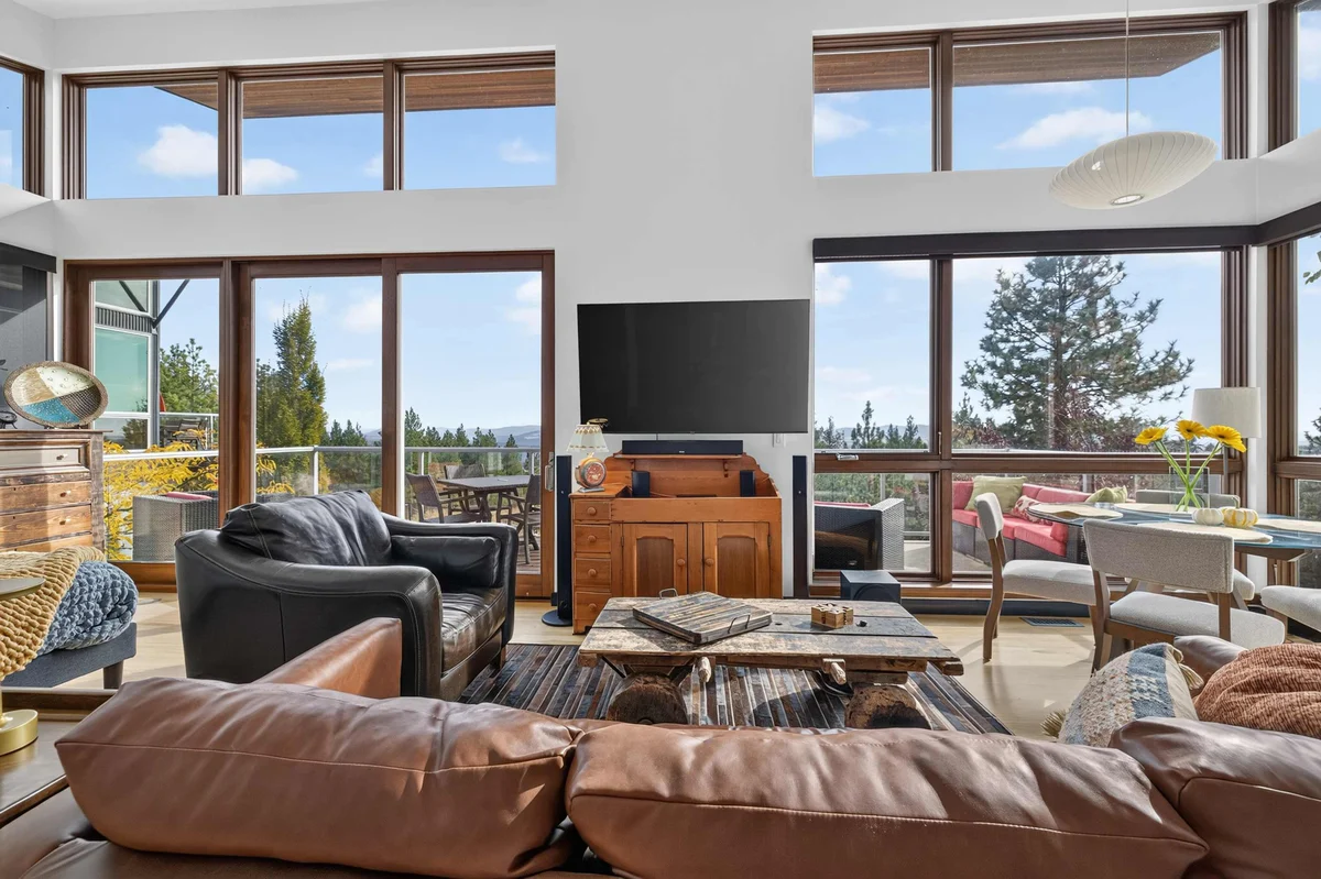 Living room with floor-to-ceiling windows and leather sofas at The Skyhouse at Forever View