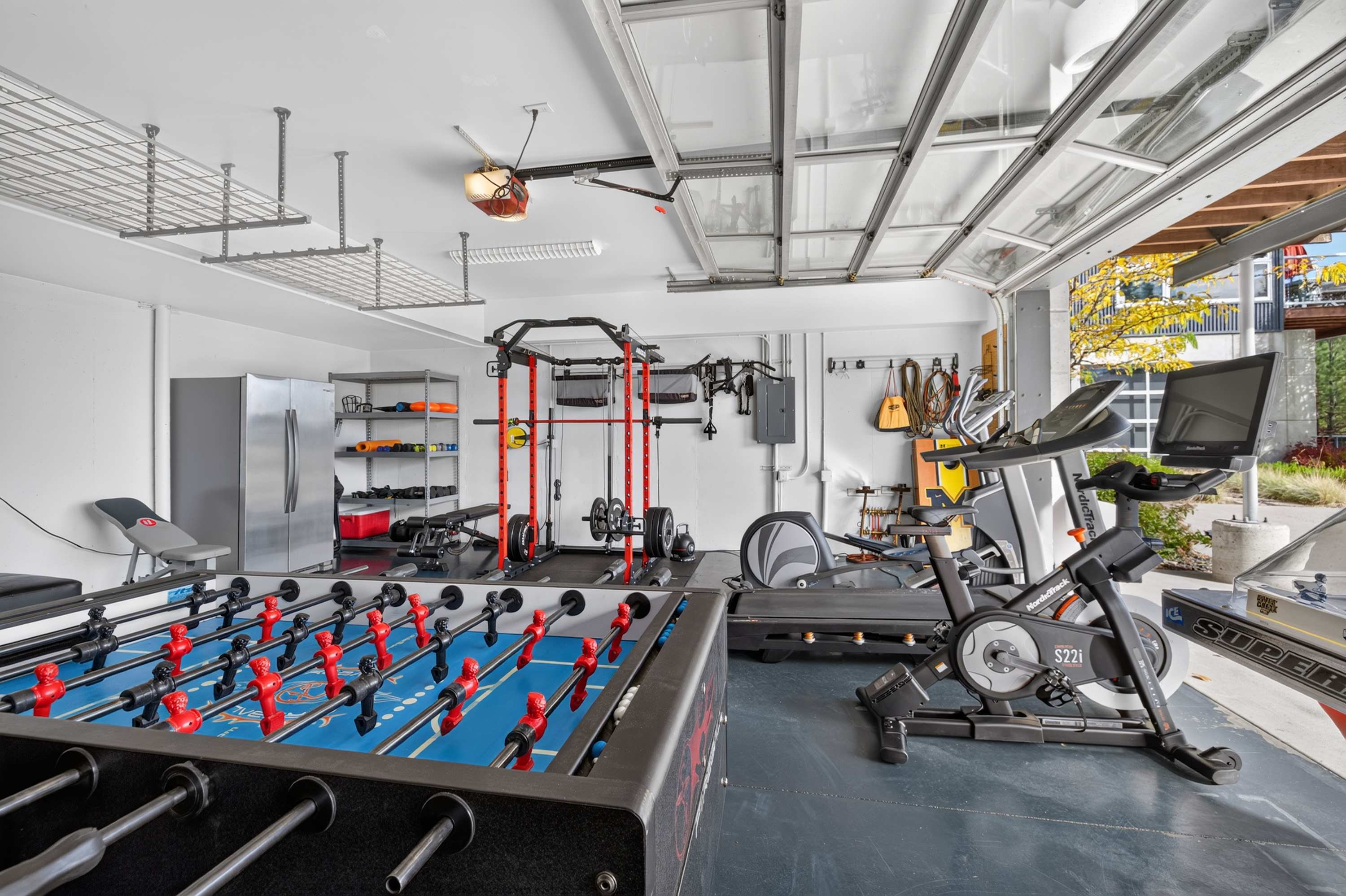 Gym and recreation space at The Skyhouse with foosball table, squat rack, treadmill, and stationary bike